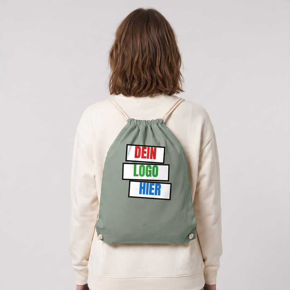 KI-generiert: Turnbeutel Westford Mill WM160 Organic Cotton InCo. Gymsac in Dusty Green – Modelfoto